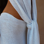 A close-up of a baby blue drape skirt and drape top, showing the textured fabric and the side cutout.