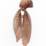 Coral print headscarf with orange and teal pattern on a white background
