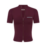 A short-sleeve, fitted zip-up jacket in deep burgundy, featuring a high mock neck, a front zipper, and blue text branding on the chest, displayed on a solid white background.