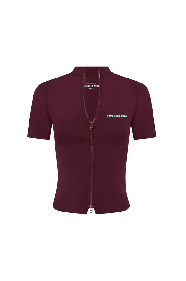 A short-sleeve, fitted zip-up jacket in deep burgundy, featuring a high mock neck, a front zipper, and blue text branding on the chest, displayed on a solid white background.